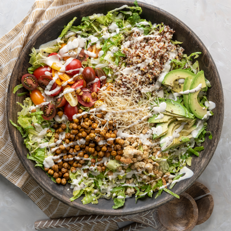 Chopped Caesar salad with fresh vegetables and croutons in a bowl, showcasing Taylor Farms' Everything Family brand.