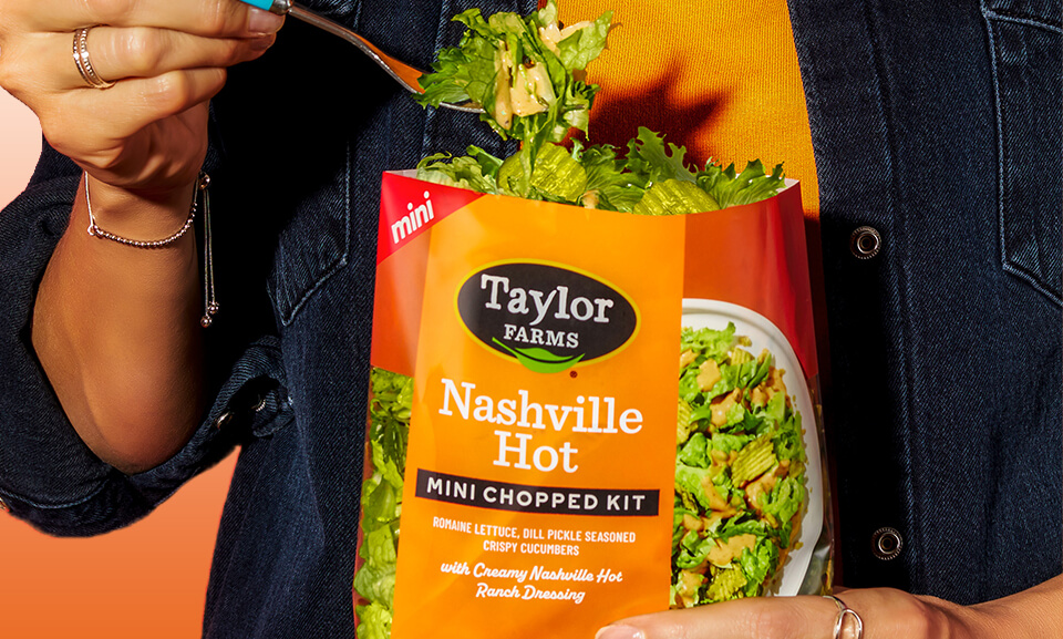 Nashville Hot Mini Chopped Salad Kit with fresh vegetables and spicy dressing in a vibrant lifestyle setting.