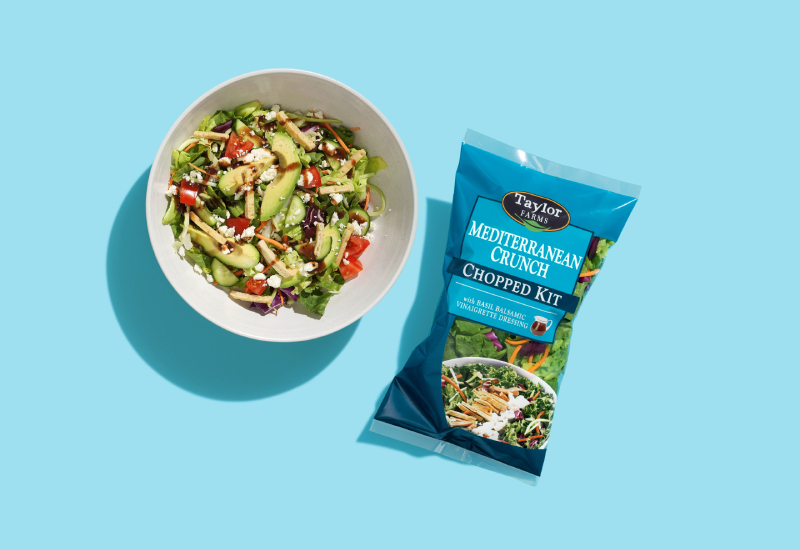 Taylor Farms Mediterranean crunch avocado salad in a bowl and a package on a blue background