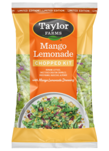 The Taylor Farms Mango Lemonade Chopped Salad Kit package, showing romaine lettuce, radicchio, sliced almonds, crouton crumbles, dried mango pieces, and the mango lemonade vinaigrette.