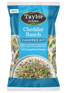 The Taylor Farms Cheddar Ranch Chopped Salad Kit package, showing chopped romaine, parmesan & cheddar-dusted crouton crumbles, red cabbage, carrot, cheddar cheese, and ranch dressing.