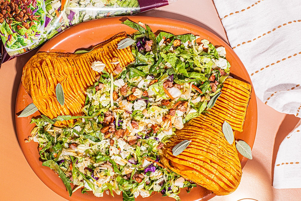 Roasted Hasselback butternut squash maple salad by Taylor Farms, featuring vibrant greens and drizzled with maple dressing.