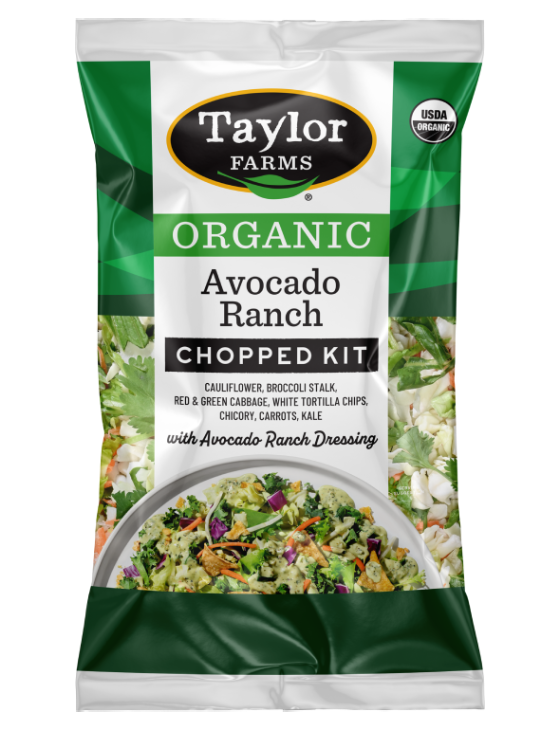 The Taylor Farms Organic Avocado Ranch Chopped Salad Kit package, showing cauliflower, broccoli stalk, red & green cabbage, chicory, carrots, kale, white tortilla chips, and the Avocado Ranch Dressing.