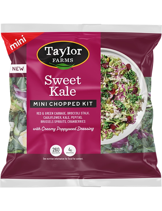 The Taylor Farms Sweet Kale Mini Chopped Salad Kit package, showing red & green cabbage, broccoli stalk, cauliflower, kale, pepitas, Brussels sprouts, cranberries, and poppyseed dressing.