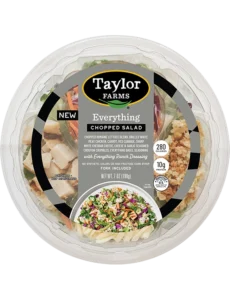 The Taylor Farms Everything Chopped Salad Bowl package, showing chopped romaine lettuce, grilled white meat chicken, carrot, red cabbage, sharp white cheddar cheese, cheese & garlic seasoned crouton crumbles, everything bagel seasoning, and everything ranch dressing.