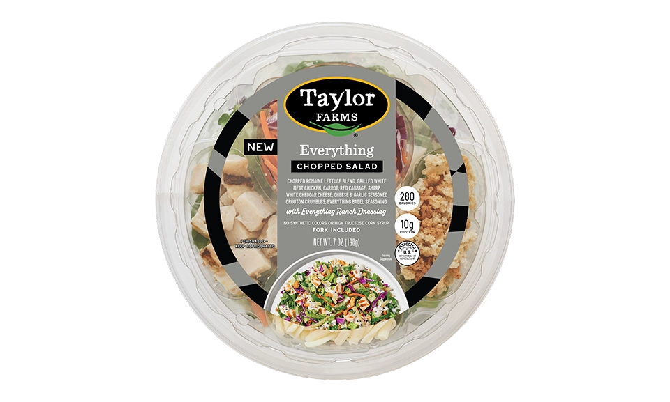 The Taylor Farms Everything Chopped Salad Bowl package, showing chopped romaine lettuce, grilled white meat chicken, carrot, red cabbage, sharp white cheddar cheese, cheese & garlic seasoned crouton crumbles, everything bagel seasoning, and everything ranch dressing.