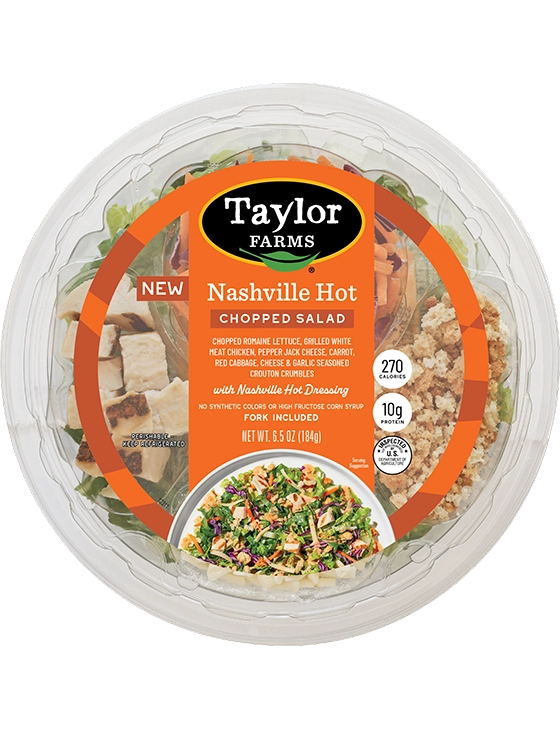 The Taylor Farms Nashville Hot Chopped Salad Bowl package, showing chopped romaine lettuce, red cabbage, carrots, grilled white meat chicken, pepper jack cheese, crouton crumbles, and Nashville hot ranch dressing.