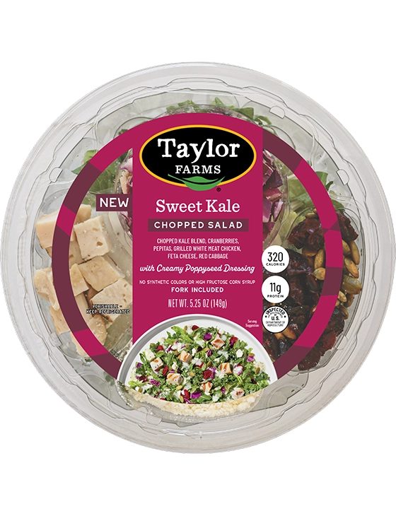 The Taylor Farms Sweet Kale Chopped Salad Bowl package, showing chopped kale and red cabbage, dried cranberries, pepitas, feta cheese, grilled white meat chicken, and creamy poppyseed dressing.