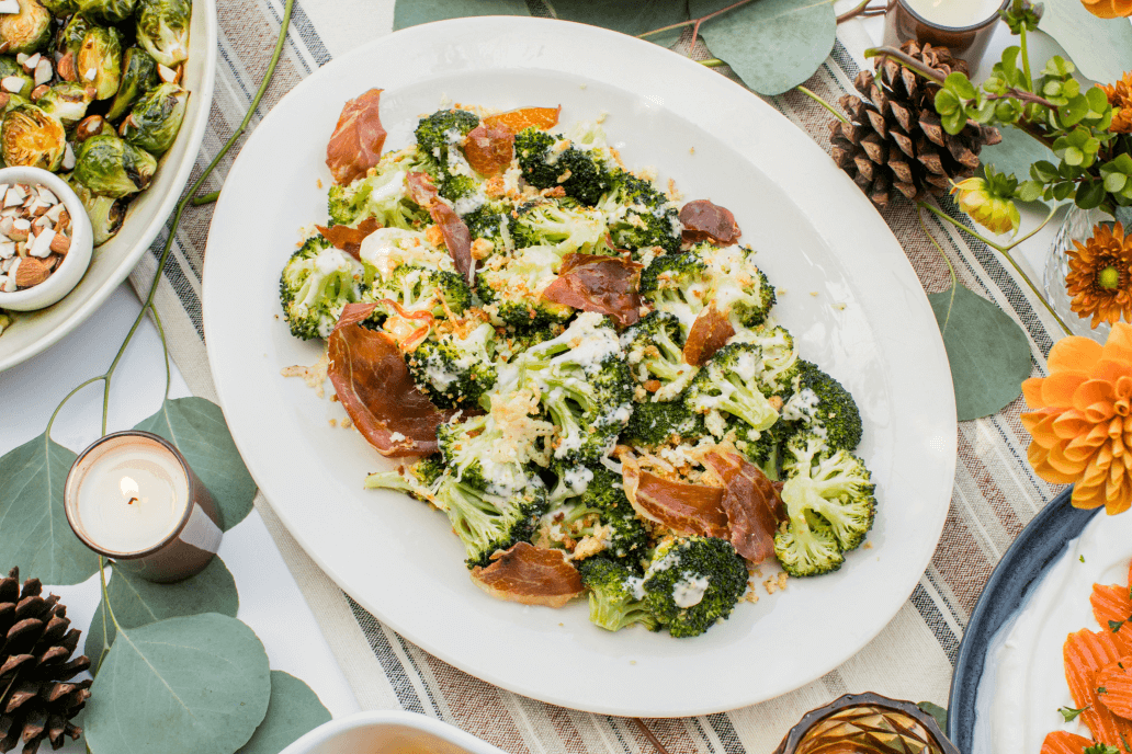 Broccoli Caesar salad topped with crispy prosciutto, fresh vegetables, and creamy dressing.