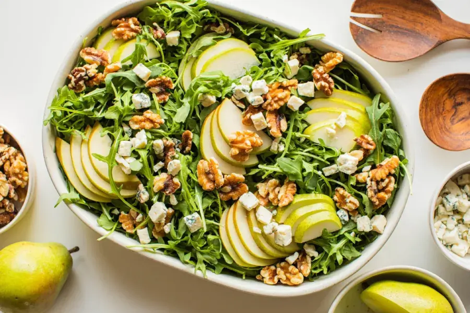 Fresh Taylor Farms pear and arugula salad with vibrant greens and sliced pears, perfect for a light, healthy meal.